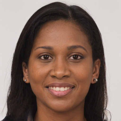 Joyful black young-adult female with long  brown hair and brown eyes