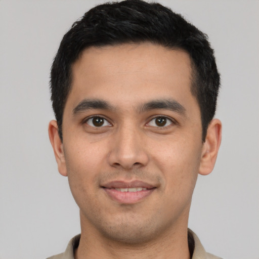 Joyful latino young-adult male with short  black hair and brown eyes