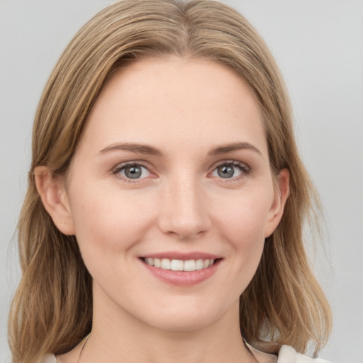 Joyful white young-adult female with medium  brown hair and grey eyes