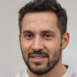 Joyful white adult male with short  black hair and brown eyes