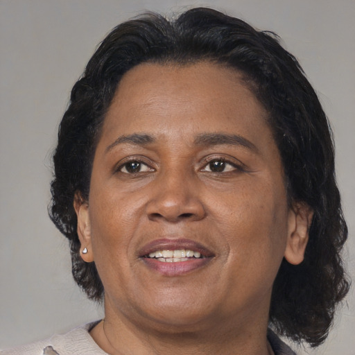 Joyful black adult female with medium  brown hair and brown eyes