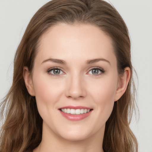 Joyful white young-adult female with long  brown hair and grey eyes