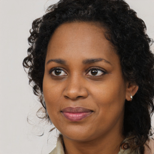 Joyful black young-adult female with long  black hair and brown eyes