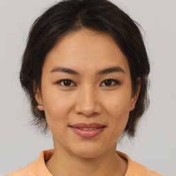 Joyful asian young-adult female with medium  brown hair and brown eyes