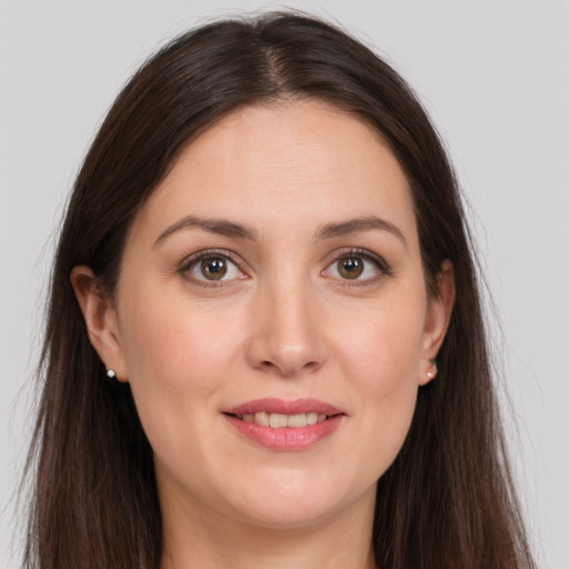 Joyful white young-adult female with long  brown hair and grey eyes