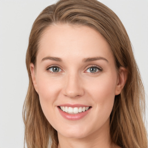 Joyful white young-adult female with long  brown hair and grey eyes