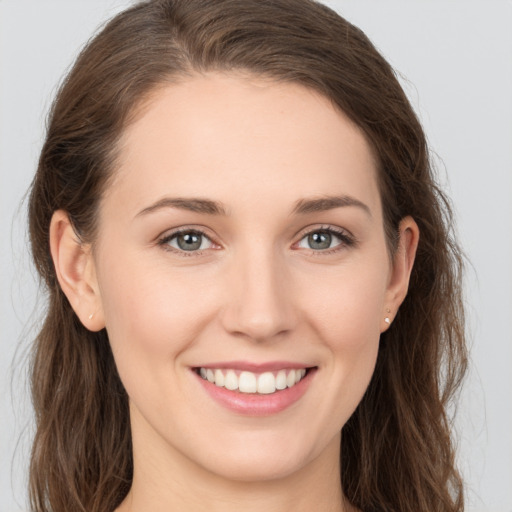 Joyful white young-adult female with long  brown hair and grey eyes