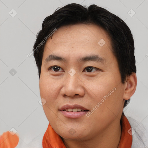 Joyful asian adult male with short  brown hair and brown eyes