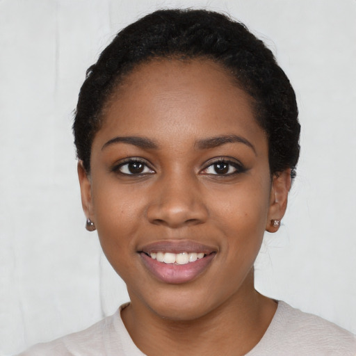 Joyful black young-adult female with short  black hair and brown eyes