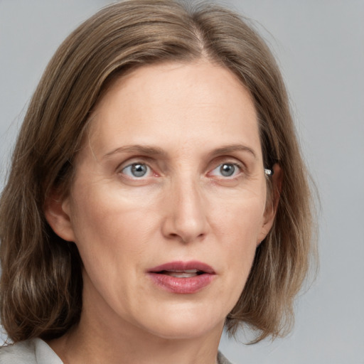 Joyful white adult female with medium  brown hair and grey eyes