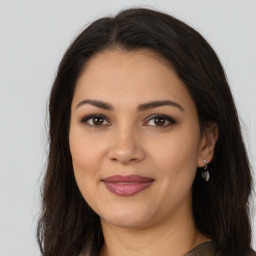 Joyful latino young-adult female with long  brown hair and brown eyes