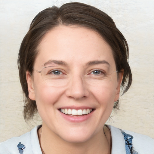 Joyful white adult female with medium  brown hair and blue eyes