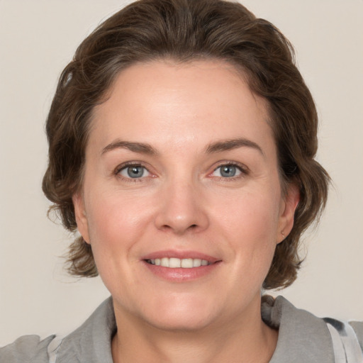 Joyful white adult female with medium  brown hair and grey eyes