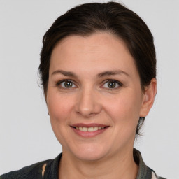 Joyful white young-adult female with medium  brown hair and grey eyes