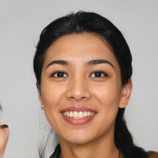 Joyful latino young-adult female with medium  black hair and brown eyes