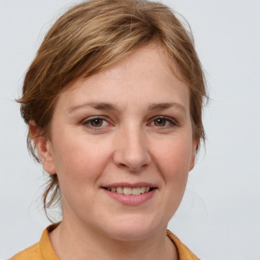 Joyful white young-adult female with medium  brown hair and blue eyes