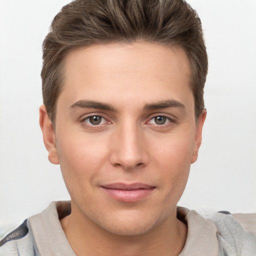 Joyful white young-adult male with short  brown hair and grey eyes