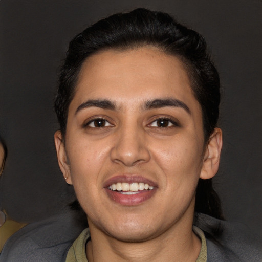 Joyful latino young-adult female with short  black hair and brown eyes
