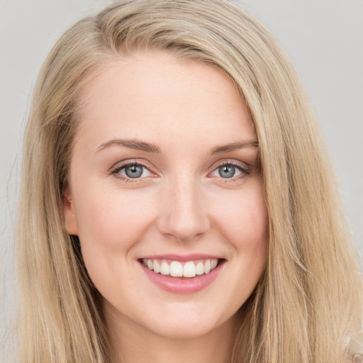 Joyful white young-adult female with long  brown hair and blue eyes