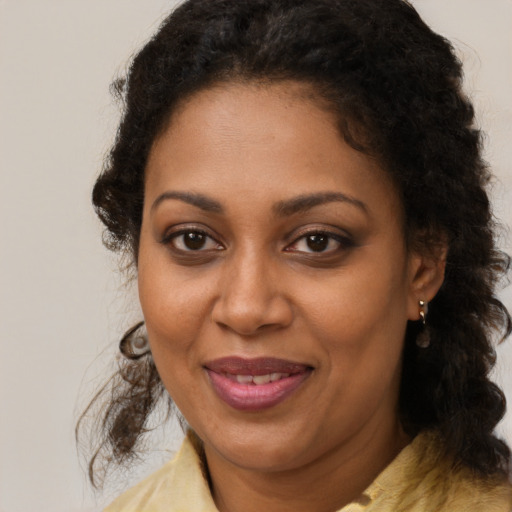 Joyful black adult female with medium  brown hair and brown eyes