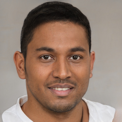 Joyful latino young-adult male with short  brown hair and brown eyes