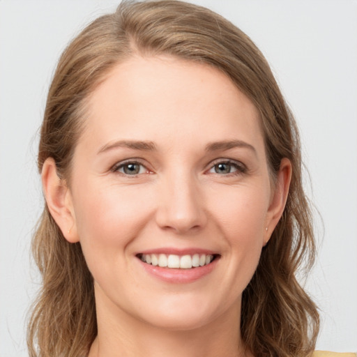 Joyful white young-adult female with long  brown hair and grey eyes