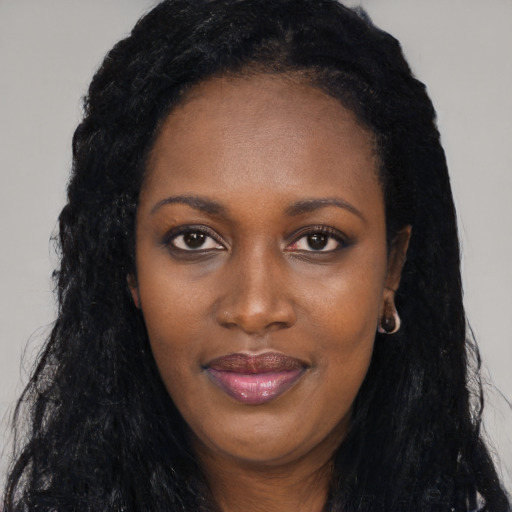 Joyful black young-adult female with long  black hair and brown eyes
