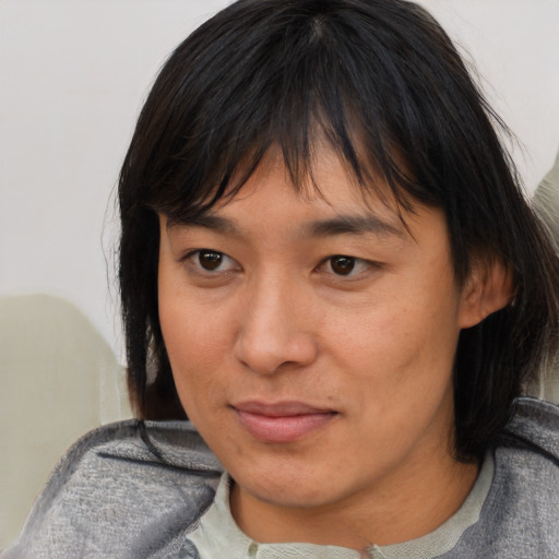 Joyful asian adult female with medium  brown hair and brown eyes
