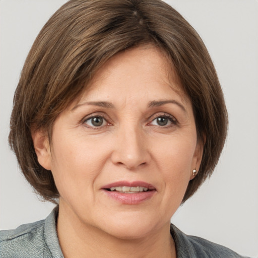 Joyful white adult female with medium  brown hair and grey eyes