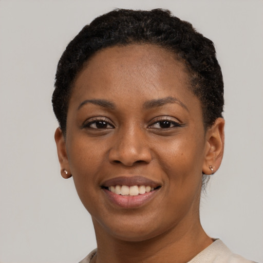 Joyful black young-adult female with short  black hair and brown eyes