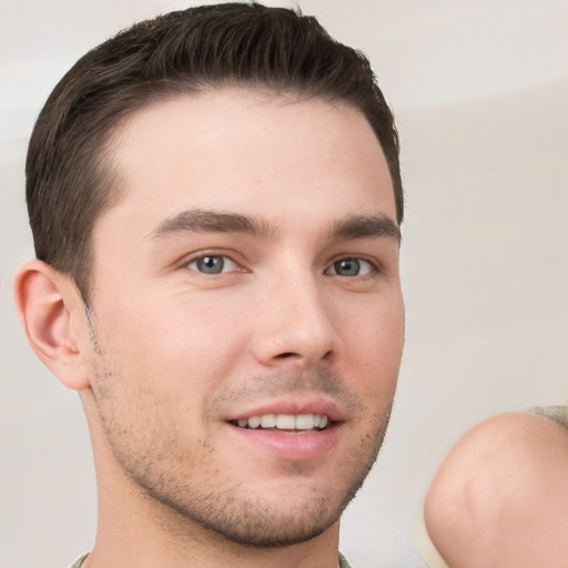 Joyful white young-adult male with short  brown hair and grey eyes