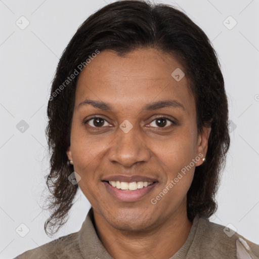 Joyful black adult female with long  brown hair and brown eyes