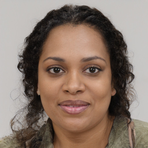 Joyful black young-adult female with long  brown hair and brown eyes