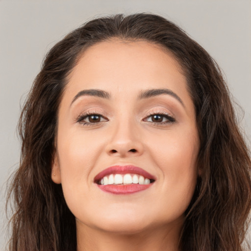 Joyful white young-adult female with long  brown hair and brown eyes