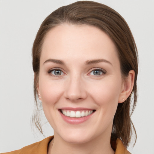 Joyful white young-adult female with medium  brown hair and blue eyes