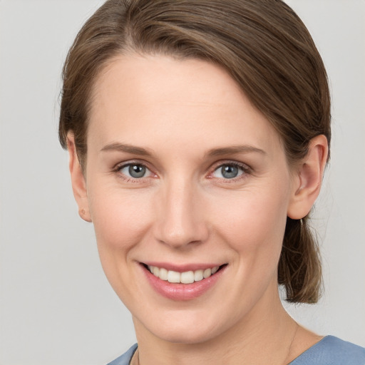 Joyful white young-adult female with medium  brown hair and grey eyes