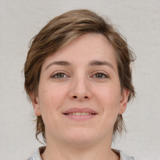 Joyful white young-adult female with medium  brown hair and grey eyes