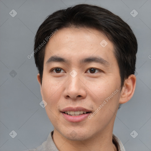 Joyful asian young-adult male with short  brown hair and brown eyes