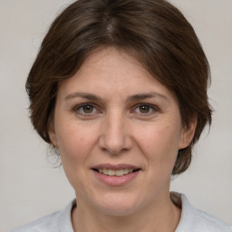 Joyful white adult female with medium  brown hair and grey eyes