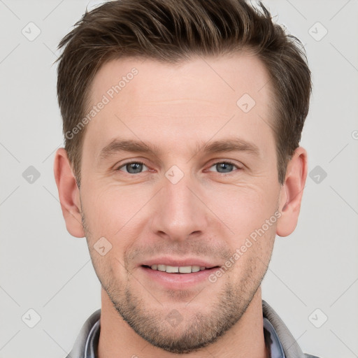 Joyful white young-adult male with short  brown hair and grey eyes