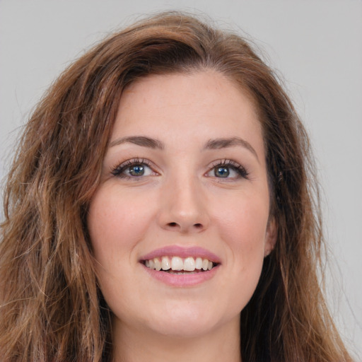 Joyful white young-adult female with long  brown hair and green eyes