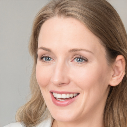 Joyful white young-adult female with long  brown hair and blue eyes