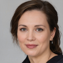 Joyful white adult female with medium  brown hair and brown eyes