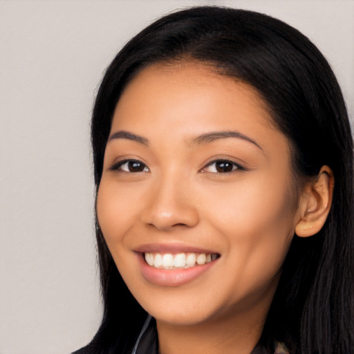 Joyful latino young-adult female with long  black hair and brown eyes