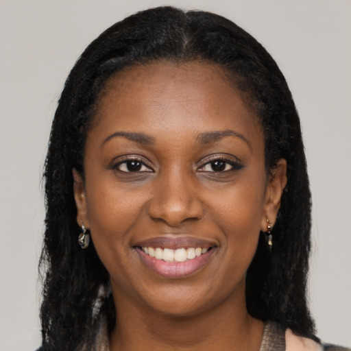 Joyful black young-adult female with long  black hair and brown eyes