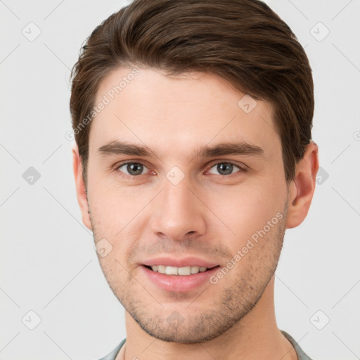 Joyful white young-adult male with short  brown hair and grey eyes