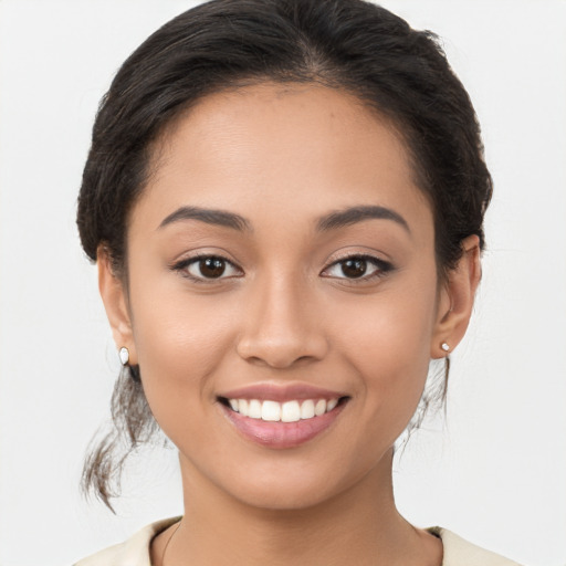 Joyful latino young-adult female with medium  brown hair and brown eyes