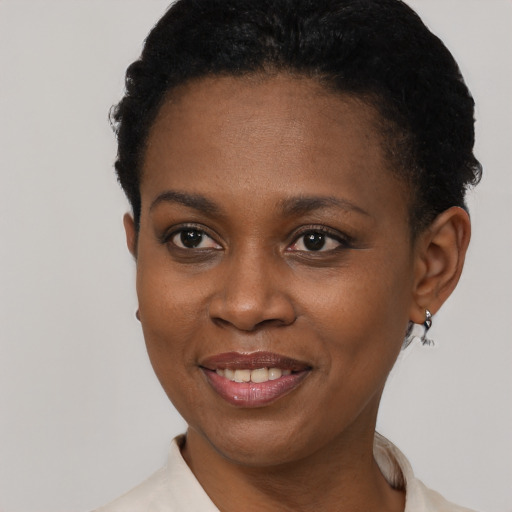 Joyful black young-adult female with short  black hair and brown eyes