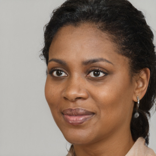 Joyful black young-adult female with medium  black hair and brown eyes