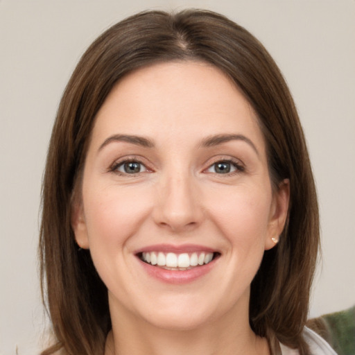 Joyful white young-adult female with medium  brown hair and grey eyes